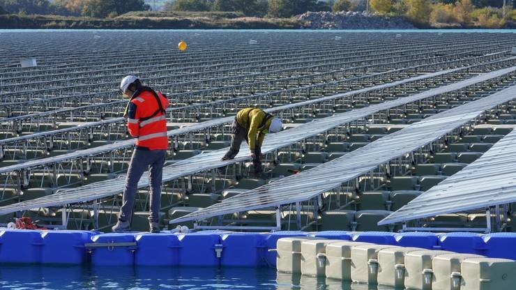 Engineers inspecting floating solar panels